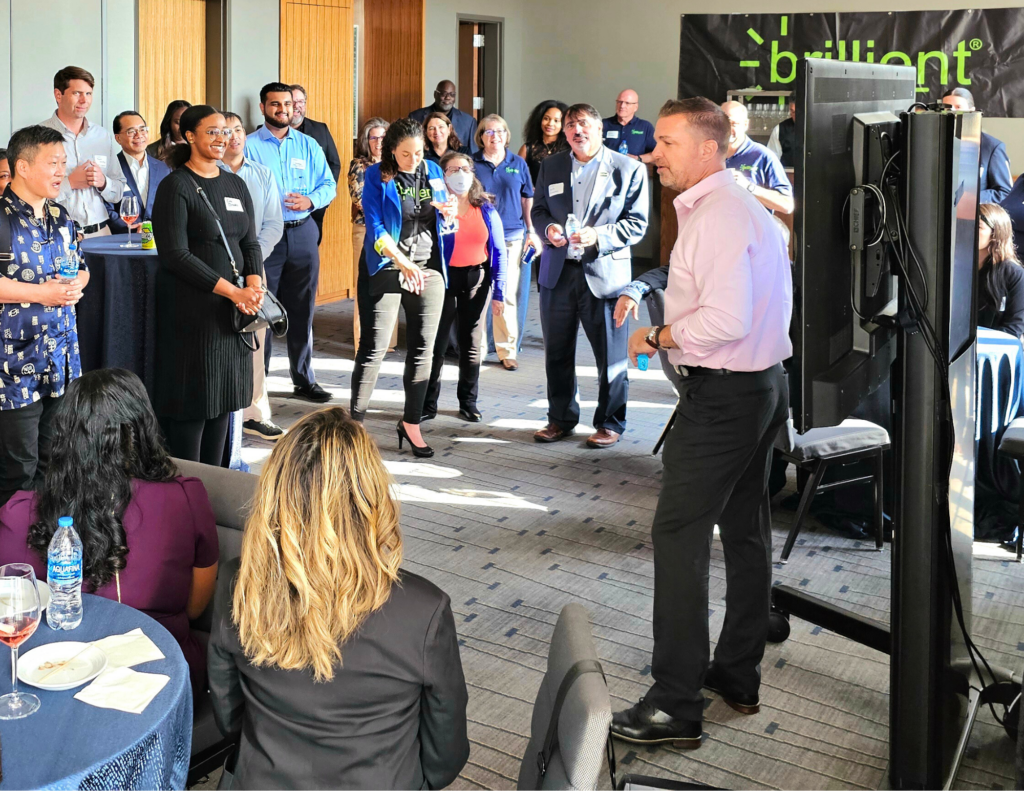 Steve Dugan of Brillient Corporation speaks to attendees at a networking event.